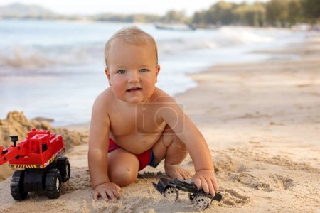Foto de Lindo niño jugando en la playa de arena - Imagen libre de derechos