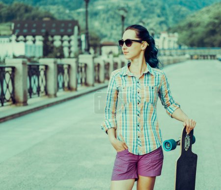 Foto de Chica de estilo de ciudad de pie con longboard - Imagen libre de derechos