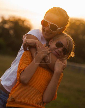 Téléchargez les photos : Deux adolescentes pendant le coucher du soleil - en image libre de droit
