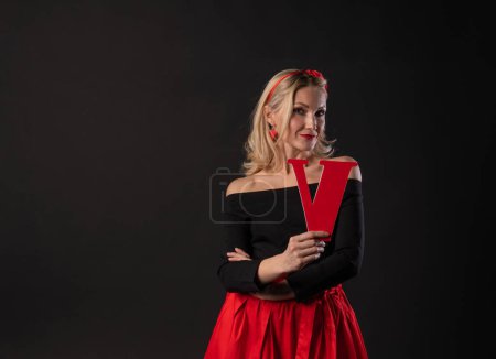 Photo for A girl holds the letters of the word LOVE love valentine background, happiness Valentine's day, on the floor hearts married space. form a banner. emotion , engagement in the red dress girl, barefoot - Royalty Free Image
