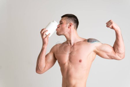 Téléchargez les photos : "Pots de protéines de remise en forme blanc sur fond blanc bodybuilder poudre forte blessure douloureuse élevée, mal colonne vertébrale massage caucasien médical, musculaire" - en image libre de droit