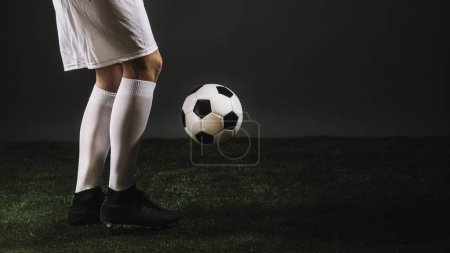 Foto de Cosecha fútbol jugador malabares bola oscuro estudio - Imagen libre de derechos