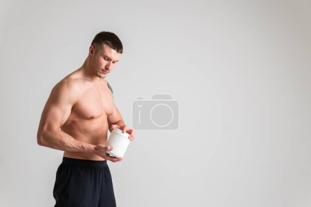 Photo for "Fitness protein jars white on white background bodybuilder powder strong high injury, ill sick caucasian massage stress, hand Touching sickness, disease suffer attractive" - Royalty Free Image