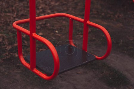 Photo for Empty children's swing red color close-up. The concept of sadness, loss, death, mourning, orphanhood or loneliness - Royalty Free Image