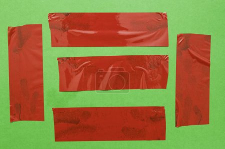 Téléchargez les photos : Différentes parties de ruban rouge mur vert - en image libre de droit