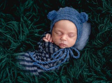 Téléchargez les photos : Mignon nouveau-né endormi portant un chapeau tricoté bleu - en image libre de droit