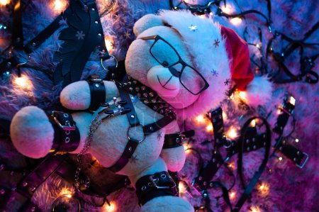 Téléchargez les photos : Ours dans un chapeau de Père Noël est un cadeau de Noël pour les jeux BDSM d'un sex-shop à la lumière du néon pour la nouvelle année - en image libre de droit
