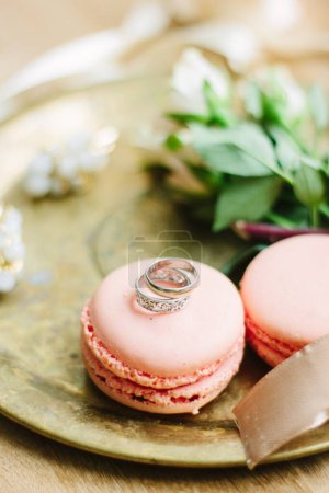 Téléchargez les photos : "Anneaux de mariage sur un gâteau macaron comme décoration" - en image libre de droit
