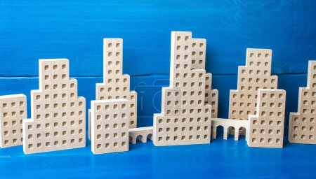 Photo for "City of figures of buildings on a blue background. Concept for real estate, urban environment and transport infrastructure. City management and planning. Construction industry, growth and development." - Royalty Free Image