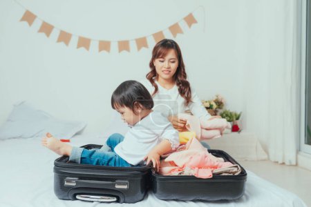 Photo for Mom and daughter are packing suitcases for the trip. - Royalty Free Image