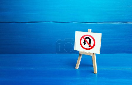 Photo for "Easel with backward turning prohibition symbol. No turning back traffic sign. Assertiveness and striving, moving forward without retreating. Obstinacy, irrevocability. Cultivate personal qualities" - Royalty Free Image