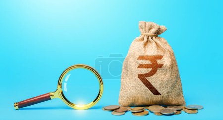 Photo for "Indian rupee money bag and magnifying glass. Revising the budget to save money. Most favorable conditions for deposits. Origin of capital funds. Search for financing. Financial audit control." - Royalty Free Image