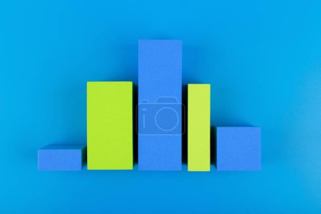 Foto de "Diagrama gráfico de negocios o gráfico de rendimiento con barras azules y verdes con dinámica de subida y bajada sobre fondo azul" - Imagen libre de derechos