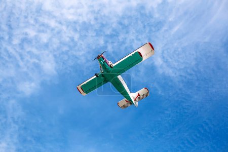 Photo for "Small single engine vintage colorful airplane in a blue cloudy sky" - Royalty Free Image