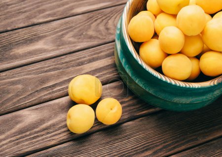 Téléchargez les photos : Abricots frais mûrs dans un bol en bois - en image libre de droit
