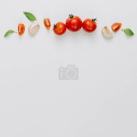 Téléchargez les photos : Tranche entière tomates cerises gousse d'ail basilic fond blanc - en image libre de droit