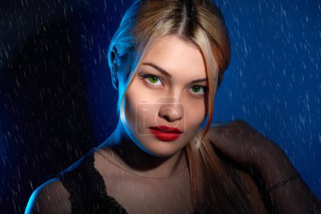 Foto de Retrato de una chica rubia con maquillaje brillante en luz azul - Imagen libre de derechos