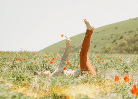 Photo for Woman relaxing on flower meadow. - Royalty Free Image