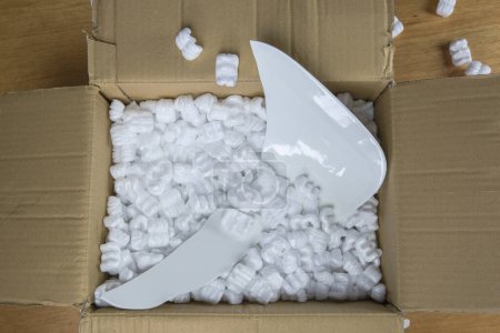 Photo for Broken plate in damaged cardboard box top view, damaged home delivery unpacking box - Royalty Free Image