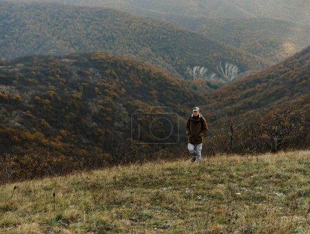 Photo for Hiker man climbing the hill - Royalty Free Image