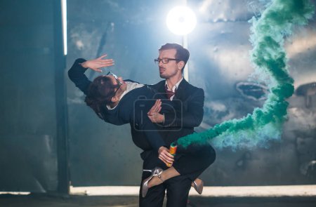Téléchargez les photos : "Pasadoble, danse latine solo et danse contemporaine - Beau homme et belle femme dansant dans un nuage de fumée
." - en image libre de droit
