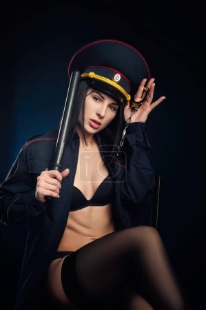 Téléchargez les photos : Portrait de femme sexy police avec casquette de police et menottes - en image libre de droit