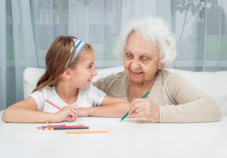 Photo for Little girl and her grandmother drawing with pencils - Royalty Free Image