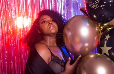 Photo for Portrait of a beautiful african american woman against twinkling background. Birthday party, nightclub and nightlife concept - Royalty Free Image
