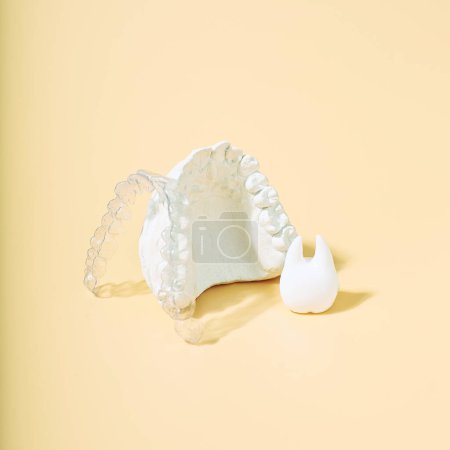 Téléchargez les photos : Thème dentaire orthodontique sur fond jaune.Aligneurs dentaires invisibles transparents ou appareils dentaires adaptables pour un traitement dentaire orthodontique - en image libre de droit