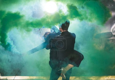 Photo for "Pasadoble, latin solo dance and contemporary dance - Handsome man and woman dancing into smoke cloud." - Royalty Free Image