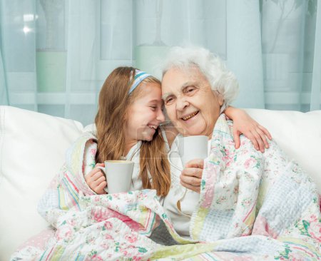 Photo for Close-up shot of grandmother and granddaughter drink tea - Royalty Free Image