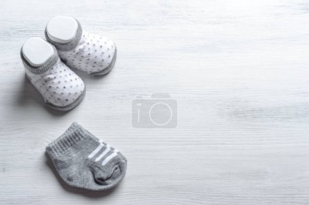 Foto de Nuevos calcetines y zapatos de bebé sobre fondo de madera - Imagen libre de derechos