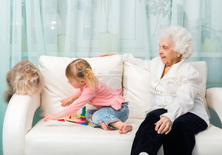 Photo for Close-up shot of grandmother and granddaugter on sofa - Royalty Free Image