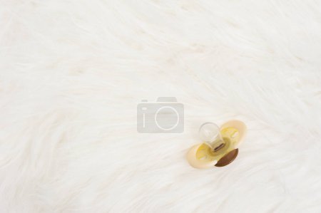 Photo for Yellow baby pacifier on bed - Royalty Free Image