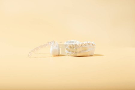 Photo for Orthodontic dental theme on yellow background. Transparent invisible dental aligners or braces for an orthodontic dental treatment - Royalty Free Image