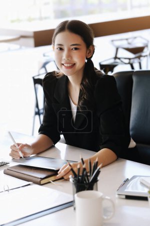 Photo for Company employees are sitting at work using tablet and documents in their work - Royalty Free Image