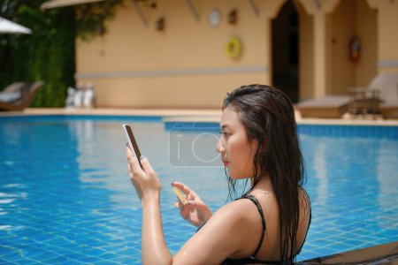Foto de Pago en línea, Una adolescente que nada está utilizando su teléfono inteligente con su tarjeta de crédito para hacer compras. en línea vía Internet - Imagen libre de derechos
