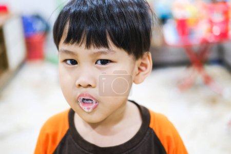 Téléchargez les photos : Un jeune enfant profite de la mousse de salive qui crache de sa bouche - en image libre de droit