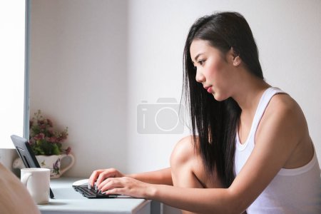 Foto de "new normal, a businesswoman using computer to work for a company Via the internet on your desk at home." - Imagen libre de derechos