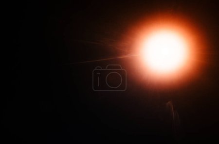 Téléchargez les photos : Éclair de soleil naturel abstrait ou étoile lointaine sur le fond noir - en image libre de droit