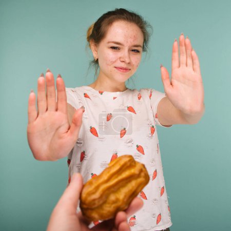 Téléchargez les photos : "Portrait de jeune fille boutonneuse hows mains arrêter sur un délicieux gâteau
" - en image libre de droit