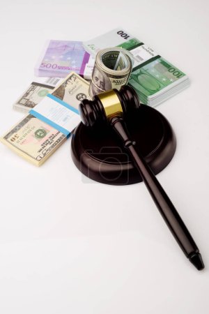 Foto de Vista superior Martillo del juez y paquetes de dólares y billetes en euros sobre un fondo blanco - Imagen libre de derechos