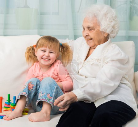 Foto de Niña con la abuela en un sofá - Imagen libre de derechos