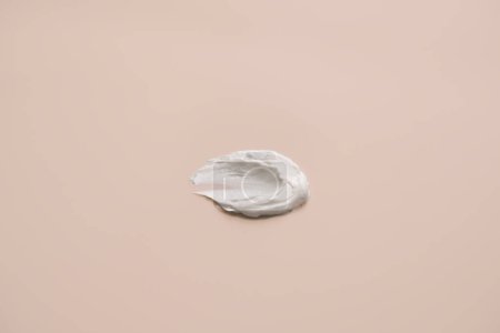 Foto de Textura de crema blanca delicada sobre un fondo beige - Imagen libre de derechos