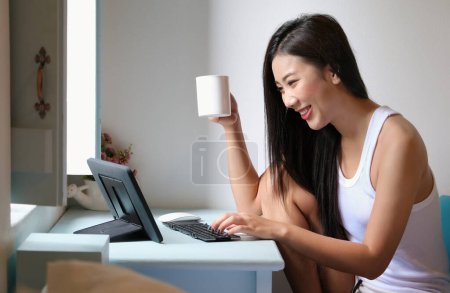 Téléchargez les photos : "new normal, a businesswoman using tablet to work for a company Via the internet on your desk at home." - en image libre de droit