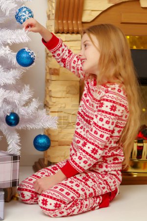 Foto de Una niña está decorando un árbol de Navidad
. - Imagen libre de derechos