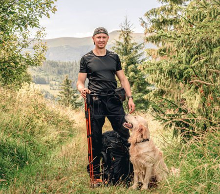 Téléchargez les photos : Homme avec chien trekking montagne ensoleillée - en image libre de droit