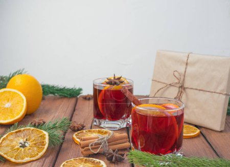 Photo for Christmas mulled red wine with spices and fruits on a wooden rustic table. Traditional hot drink at Christmas time - Royalty Free Image