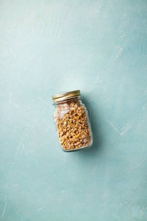 Photo for Home granola in a glass jar on blue concrete background - Royalty Free Image