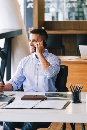 Foto de Gerente de marketing masculino que usa el teléfono para hablar con la empresa de capital riesgo para aumentar el potencial de ganancias. - Imagen libre de derechos